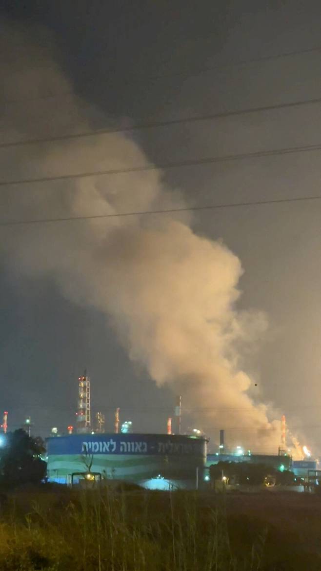 16일(현지시각) 이스라엘 하이파의 정유소가 이란의 미사일 공격으로 연기가 피어오르고 있다. 하이파/로이터 연합뉴스