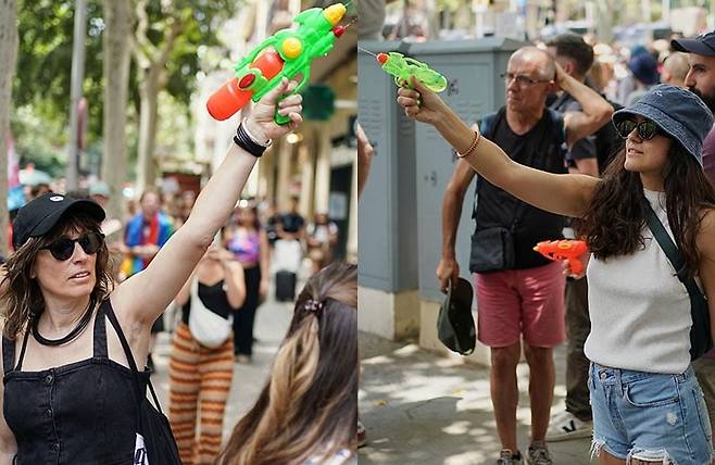 15일(현지시간) 스페인 바르셀로나에서 열린 과잉 관광 항의 시위 참석자가 물총을 쏘고 있다. 사진=AP