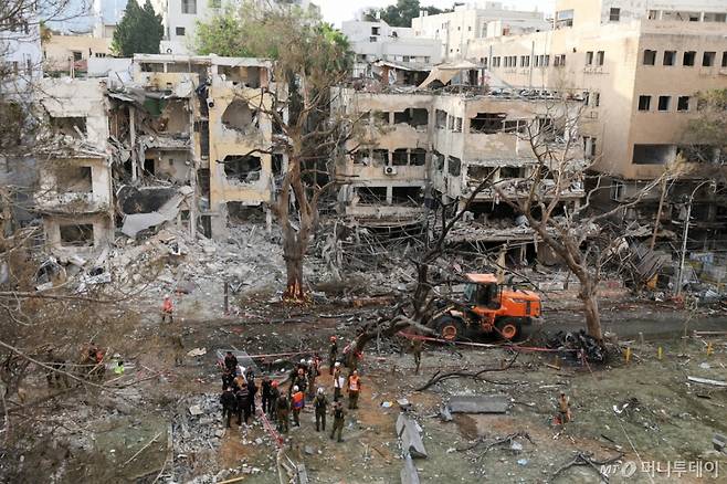 (텔아비브 로이터=뉴스1) 강민경 기자 = 16일 이란이 이스라엘 텔아비브를 향해 미사일이 발사한 후 긴급 구조대가 손상된 건물에 출동해 있다. 2025.6.16 ⓒ 로이터=뉴스1 Copyright (C) 뉴스1. All rights reserved. 무단 전재 및 재배포, AI학습 이용 금지. /사진=(텔아비브 로이터=뉴스1) 강민경 기자