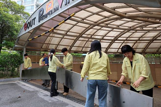 지난 13일 오전 광주 북구 용봉동 한 아파트 지하주차장 입구에서 북구청과 행정복지센터 직원들이 장마 대비 차수막 설치 점검하고 있다. 연합뉴스