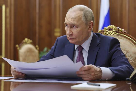 블라디미르 푸틴 러시아 대통령이 16일(현지시간) 러시아 모스크바 크렘린궁에서 열린 회담에서 미하일 라즈보자예프 세바스토폴 주지사의 발언을 듣고 있다. AP=연합뉴스