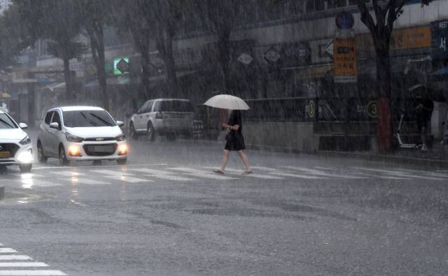 ▲ 더위를 식혀주는 소나기가 내린 지난 7일 강원 춘천 중앙로에서 한 시민이 발길을 재촉하고 있다. 김정호