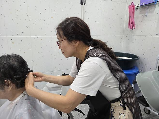 아내 임영희씨가 한 노인복지센터에서 어르신의 머리를 다듬어 주고 있다. 사진제공=유튜브 '김호겸의 유랑악단'