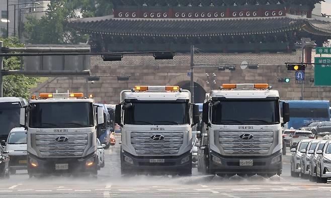 낮 기온이 30도를 웃돌고 후텁지근한 날씨가 계속된 지난 17일 서울 남대문 인근 도로에서 폭염대비 도로열섬현상 완화를 위한 도로 물청소가 이루어지고 있다. 연합뉴스