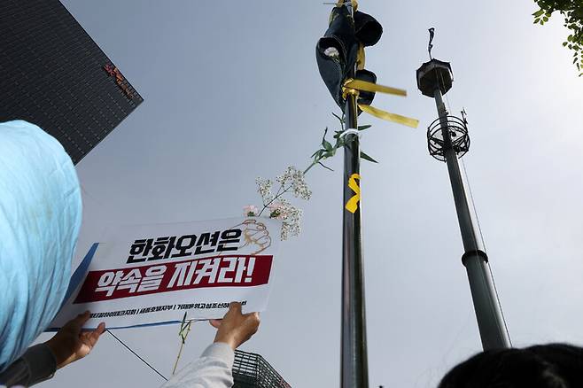 한국옵티칼하이테크지회, 세종호텔지부, 거제통영고성조선하청지회 조합원들과 연대 시민 등이 5월8일 서울 중구 세종호텔 앞 고공농성장에서 ‘국회가 고공농성 사업장 문제 해결하라!’ 기자회견을 마치고 행진해 한화빌딩 앞 고공 농성장에서 손팻말을 들고 있다. 김영원 기자 forever@hani.co.kr