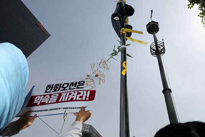 한국옵티칼하이테크지회, 세종호텔지부, 거제통영고성조선하청지회 조합원들과 연대 시민 등이 8일 오전 서울 중구 세종호텔 앞 고공농성장에서 ‘국회가 고공농성 사업장 문제 해결하라!’ 기자회견을 마치고 행진해 한화빌딩 앞 고공농성장에서 손팻말을 들고 있다. 김영원 기자 forever@hani.co.kr