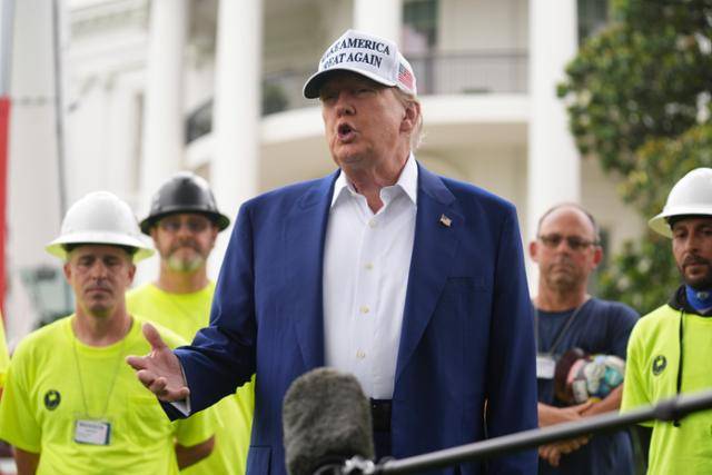 도널드 트럼프(앞줄 가운데) 미국 대통령이 18일 미국 워싱턴 백악관에서 열린 깃대 설치 행사 전에 기자들의 질문에 답변하고 있다. 워싱턴=AP 연합뉴스