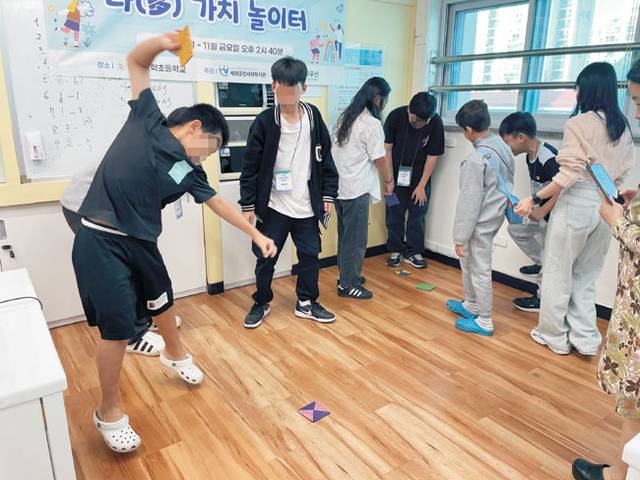 지난해 세화종합사회복지관의 ‘다(多)가치 놀이터’ 사업을 통해 한국 전통놀이에 대해 배운 이주배경아동들이 직접 만든 딱지로 딱지치기를 하고 있다. 초록우산 제공