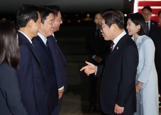 이재명 대통령이 19일 51차 주요 7개국(G7) 정상회의 일정을 마친 뒤 성남 서울공항에 도착해 마중 나온 강훈식 비서실장과 대화하고 있다. 연합뉴스