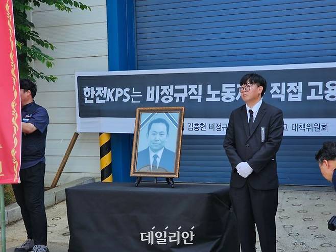 김영훈 태안화력 한전KPS비정규직지회장이 18일 오전 고 김충현씨 사망사고가 일어난 발전소 내 한전KPS 태안사무처 건물 입구에 영정 사진을 안치하고 추모 준비를 하고 있다.ⓒ뉴시스