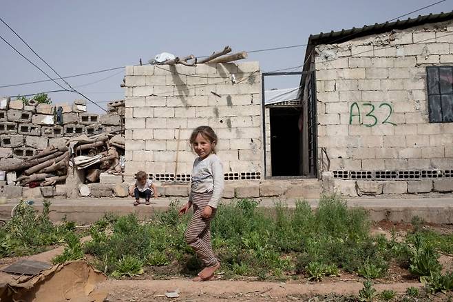 지난해 4월 25일 시리아 라카에서 여섯살인 수마야와 두살인 레일라가 가족의 집 앞에서 놀고 있다. 국제구조위원회 제공