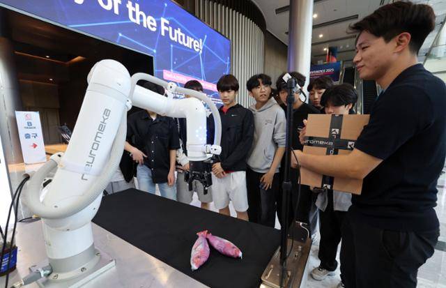 서울 강남구 코엑스에서 5일 열린 '2025 자율제조 월드쇼'를 찾은 관람객들이 산업용 협동로봇을 살펴보고 있다. 뉴스1
