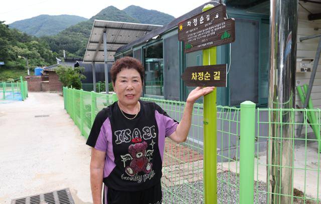 충북 괴산군 청천면 사담리 주민 차정순씨가 자신의 이름을 딴 마을 진입로 앞에서 주민들이 푯말과 안내판을 세운 사연을 소개하고 있다. 괴산군 제공
