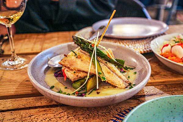 Grilled sea bass with asparagus, confit potatoes, and beurre blanc.