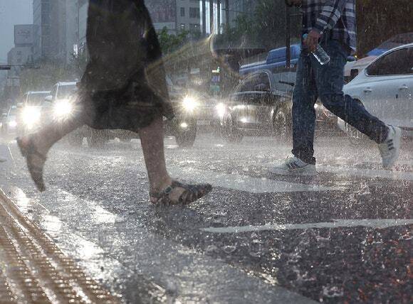 갑작스런 폭우가 내린 가운데 서울 종로구 광화문광장 인근에서 시민들이 이동하고 있다. 연합뉴스