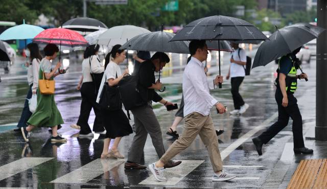 장마가 시작되며 서울 전역에 호우주의보가 내려진 20일 오전 서울 광화문네거리에서 우산을 쓴 시민들이 출근하고 있다. 뉴스1