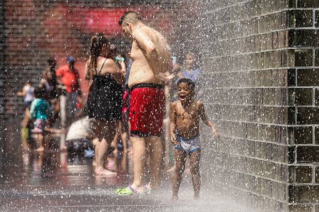 21일(현지시간) 미국 일리노이주 시카고의 기온이 섭씨 35도 이상으로 치솟자 사람들이 밀레니엄 파크의 크라운 분수를 찾아 더위를 식히고 있다. AFP 연합뉴스