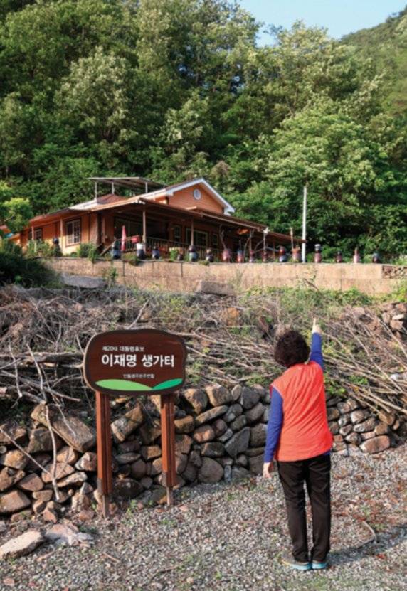 이재명 대통령 고향인 경북 안동시 예안면 도촌리에 설치된 ‘제20대 대통령후보 이재명 생가터’ 팻말. 한 주민이 지금은 밭이 된 생가터를 가리키고 있다. 뉴스1