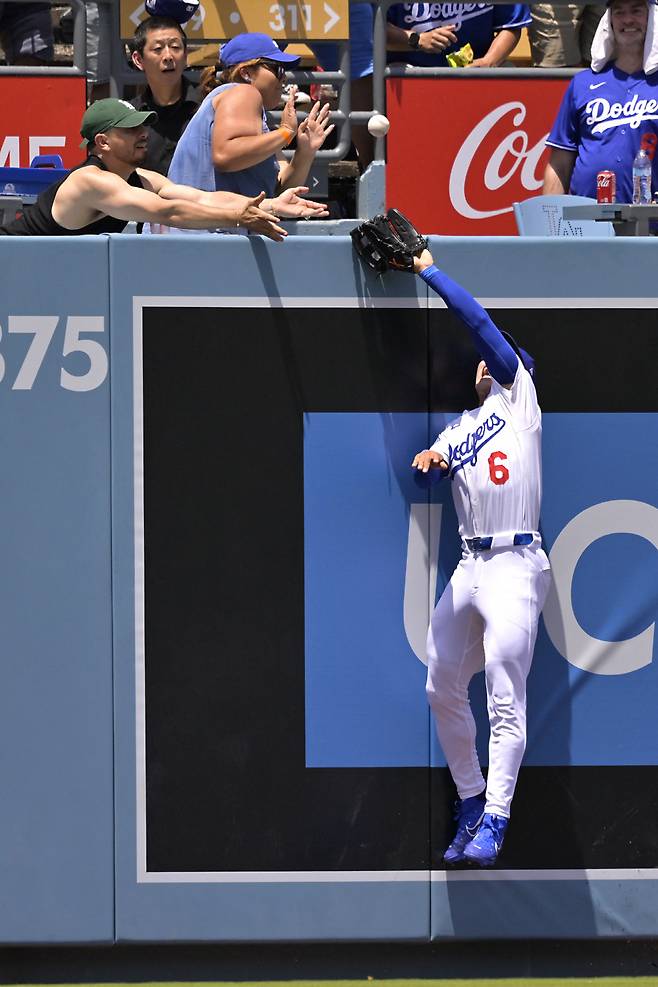 LA 다저스 중견수 김혜성이 23일(한국시각) 다저스타디움에서 열린 워싱턴 내셔널스전에서 3회초 나다니엘 로가 친 좌중간 홈런을 잡기 위해 점프하며 글러브를 뻗고 있다. 그러나 타구는 글러브와 펜스를 맞고 한 남성 팬의 손을 맞은 뒤 안으로 떨어져 인플레이 타구에서 홈런으로 번복됐다. AFP연합뉴스