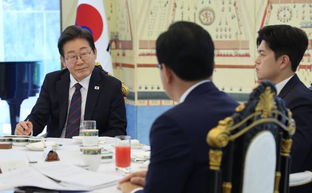 이재명 대통령이 22일 한남동 관저에서 열린 여야 지도부와의 오찬에서 송언석 국민의힘 원내대표(뒷모습)의 발언을 듣고 있다. 오른쪽은 김용태 비대위원장. 연합뉴스