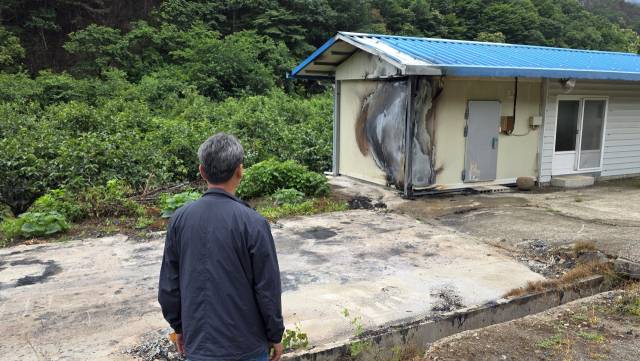 경남 산청군 시천면 한 곶감 재배 농민이 산불 피해 현장을 바라 보고 있다. 전소된 곶감건조장은 완전히 철거된 상태며, 저온창고는 건물 한쪽 면이 불에 그을려진 채 남겨졌다. 김현우 기자 khw82@