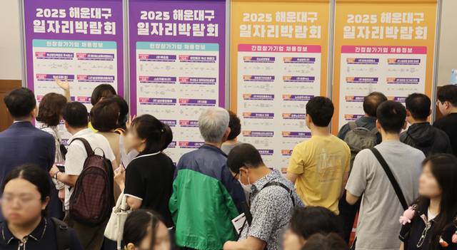 ▲ 지난 16일 오후 부산 해운대구 벡스코 제1전시장 컨벤션홀에서 열린 ‘2025 해운대구 일자리박람회’에서 구직자들이 참가기업 채용정보를 살펴보고 있다. 연합뉴스