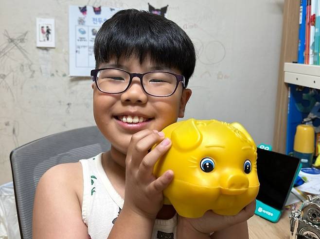 전두호군이 황금색 저금통을 들고 활짝 웃고 있다. 정혜림씨 제공