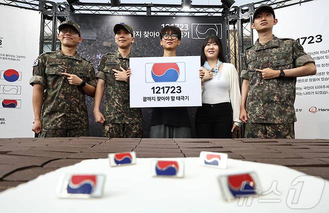 25일 서울 중구 서울역 대합실에 마련된 '태극기 부스'에서 군인들과 시민들이 태극기 배지를 패용 후 기념촬영 하고 있다. 2025.6.25/뉴스1 ⓒ News1 김도우 기자