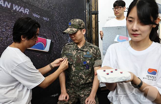 25일 서울 중구 서울역 대합실에 마련된 '태극기 부스'에서 군인들이 태극기 배지를 패용하고 있다. 2025.6.25/뉴스1 ⓒ News1 김도우 기자
