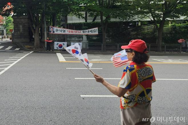 25일 서울 서초구 아크로비스타 윤석열 전 대통령 사저 앞에서 한 지지자가 태극기를 흔들고 있다. /사진=김미루 기자.