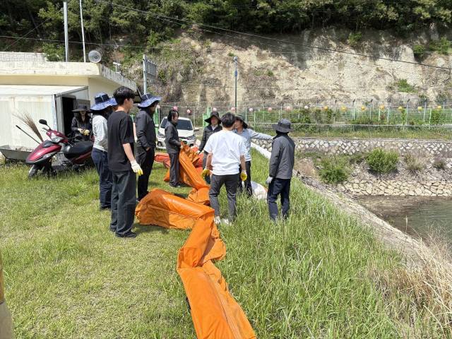 지난달 시 관계자들이 성주저수지에서 조류 차단막을 점검하고 있는 모습./창원시/