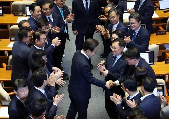 이재명 대통령이 26일 취임 이후 첫 추가경정예산안 시정연설을 위해 서울 여의도 국회 본회의장으로 입장하며 의원들과 인사나누고 있다. 국회사진기자단/박형기 기자 oneshot@donga.com