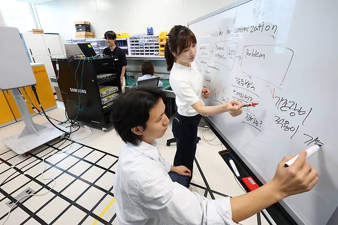 KT-삼성리서치 공동 연구팀이 무선망 최적화 기술 개발을 논의하는 모습 / KT 제공