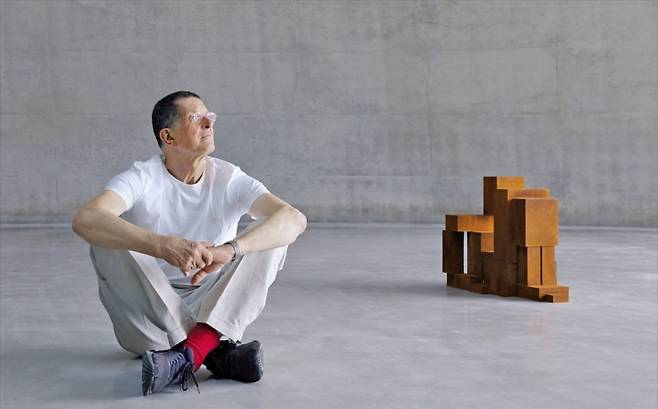 조각가 앤터니 곰리가 원주 뮤지엄산에 새로 들어선 전시장 그라운드에 설치된 자신의 작품 옆에 앉아 있다. 안도 다다오의 설계로 완성된 이 건물은 세계 최초로 곰리의 작품을 상설 전시하는 공간이다. /MAG PR 제공