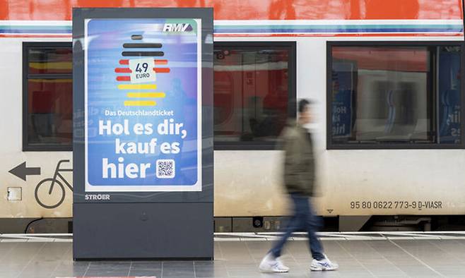 독일 프랑크푸르트의 한 역에서 한 남자가 ‘도이칠란트 티켓’ 광고판 앞을 지나가고 있다. AP연합뉴스