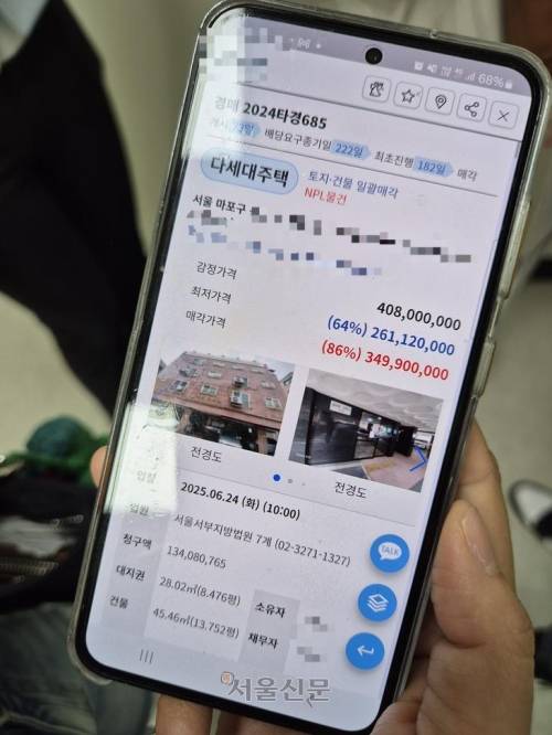 지난 24일 서울서부지법에서 진행된 경매에 참석한 30대가 휴대전화로 마포구의 한 매물 경매 결과를 보고 있다.