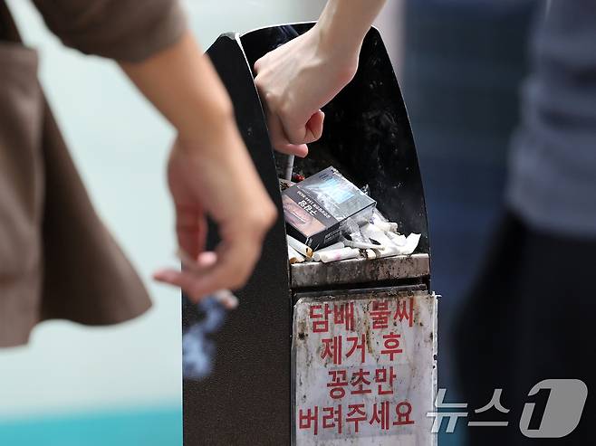 서울 종로구 흡연구역에서 시민들이 담배꽁초를 재떨이에 버리는 모습. 2024.8.14/뉴스1 ⓒ News1 황기선 기자