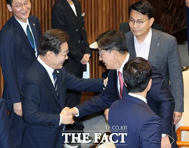 이 대통령이 26일 국회에서 열린 본회의에서 2025년도 제2회 추가경정예산안에 대한 정부의 시정연설을 마친 뒤 권성동 국민의힘 의원과 대화하며 악수하는 모습. /배정한 기자