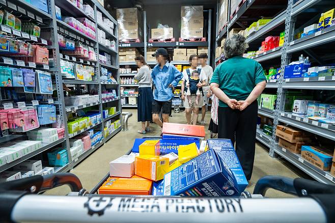 지난 24일 경기도 성남에 있는 ‘창고형 약국’ 메가팩토리약국에서 고객들이 선반에 놓인 약을 살펴보고 있다. 쇼핑 카트에는 진통제·소화제 같은 약이 잔뜩 담겨 있다. 이 약국은 지난 11일 개점 이후 연일 손님이 몰려들고 있다. /김용재 영상미디어 기자