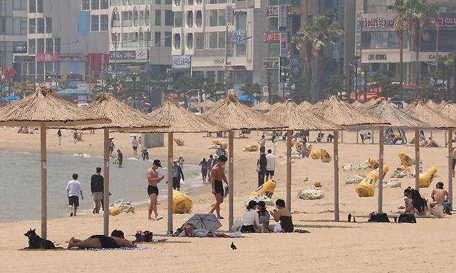 부산 수영구 광안리해수욕장에서 시민과 관광객들이 파라솔 아래에서 더위를 식히고 있다. 연합뉴스