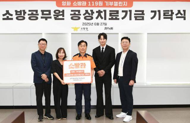 곽경택(맨 왼쪽) 감독과 배우 주원(오른쪽 두 번째) 등이 소방청 관계자들에게 치료 기금을 전달하고 있다. 소방청 제공