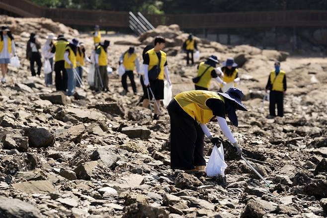 인스파이어 임직원 봉사단이 신도 선착장 주변 해양 쓰레기를 수거하고 있다