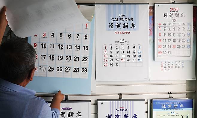 경기도 수원시 장안구의 한 인쇄소에서 관계자가 2025년 을사년 달력을 살펴보고 있다. 연합뉴스