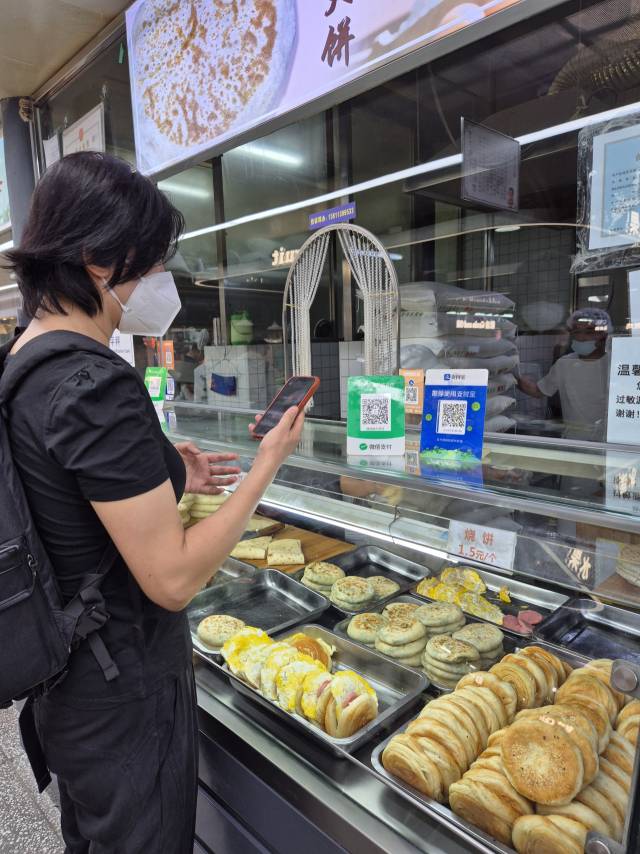 6월 29일 중국 베이징 자오쥔성 채소 시장의 한 전병 가게를 찾은 손님이 매대에 QR코드 결제용 입간판을 스캔하고 있다. 이승배 기자