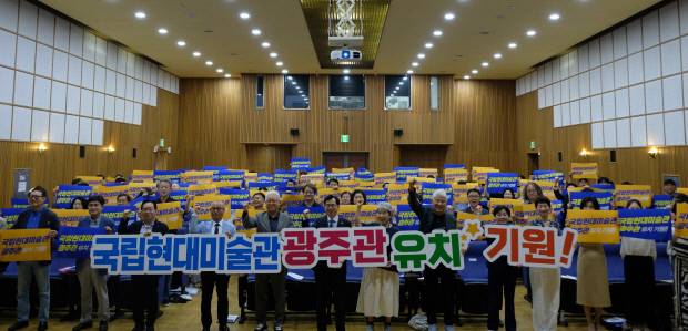 지난 30일 광주시립미술관에서 열린 ‘국립현대미술관 광주관 유치 포럼’ 참가자들이 유치 기원 손 팻말을 들고 기념촬영을 하고 있다. <광주시 제공>