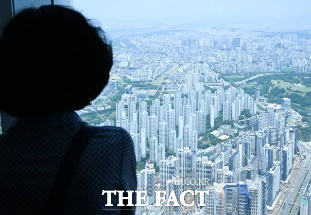 서울 강남 3구(강남·서초·송파) 지역 부동산 가격이 급등한 18일 오후 서울 송파구 롯데월드타워 서울스카이에서 한 시민이 잠실 일대 주택을 바라보고 있다./장윤석 기자