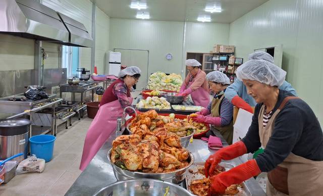 지난해 11월 옹기종기 식품 공동작업장에서 사모들이 김장 김치를 담는 모습.