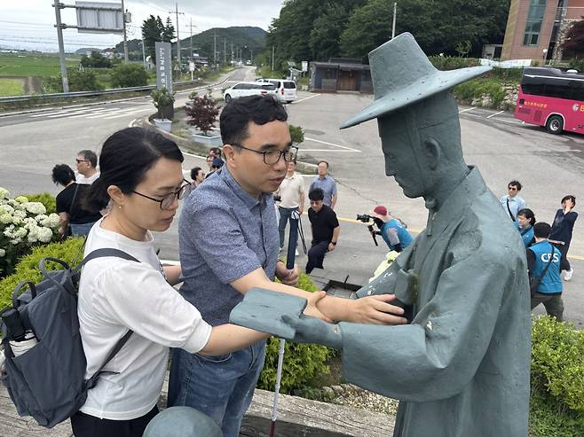 시각장애인 목회자가 선상세례 모형을 만지고 있는 모습.