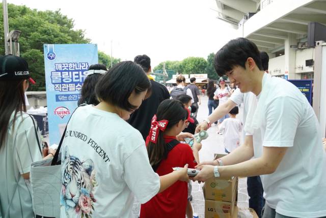 깨끗한나라 직원들이 지난달 28일 잠실야구장에서 한정판 쿨링타올을 관람객들에게 나눠주고 있다. 사진 제공=깨끗한나라