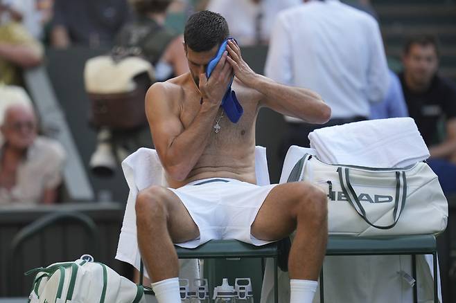 노박 조코비치가 더위에 지쳐 땀을 닦고 있다